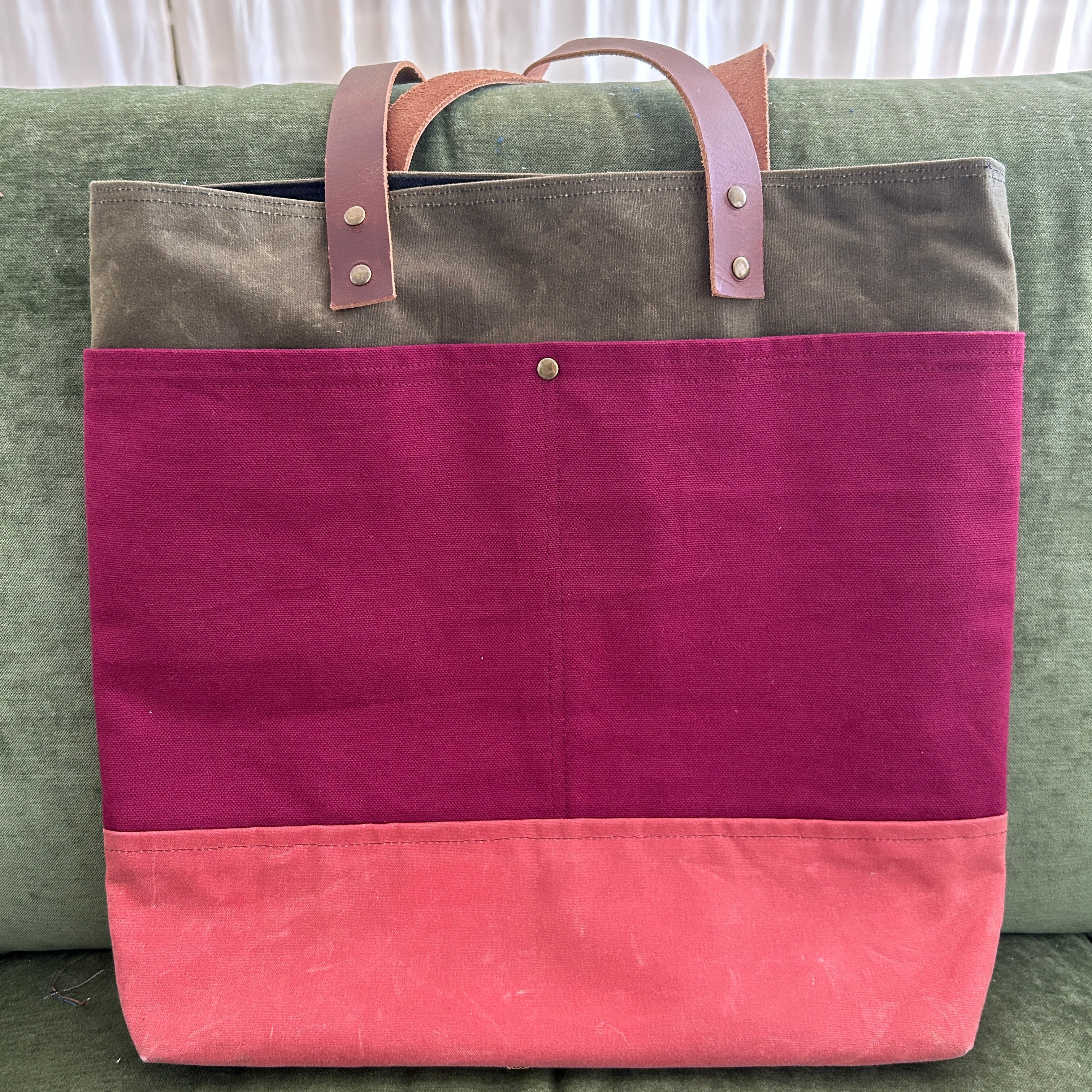 Multicolored bag with pink and purple sections on a green surface